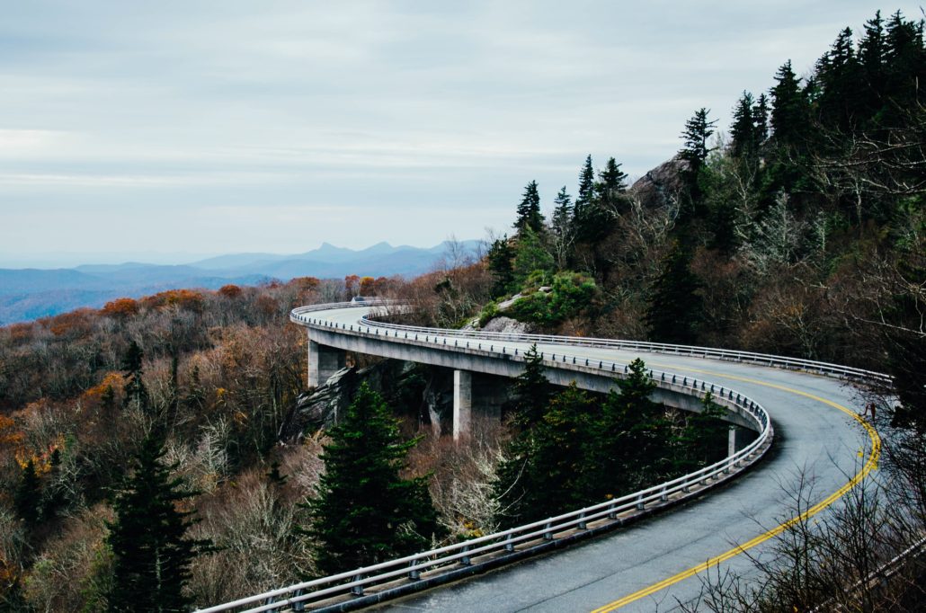 Long, winding road through mountains and forest.